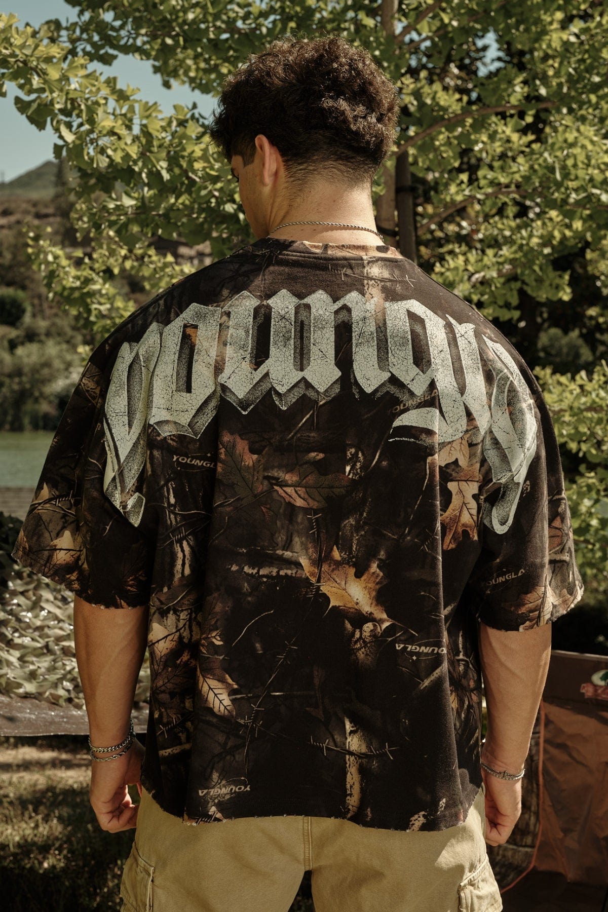 4159 - Huge Tees for Men: Bold gothic logo tee with boxy draped fit, vintage faded 100% cotton, and heavyweight presence in color Black Tree camo.